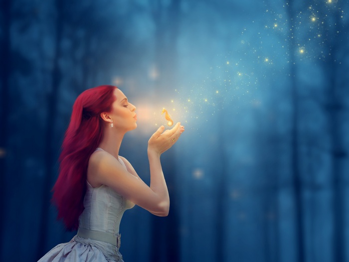 Woman blowing a seahorse with sparkles
