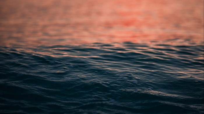 Water surface with ripples and sunset reflection