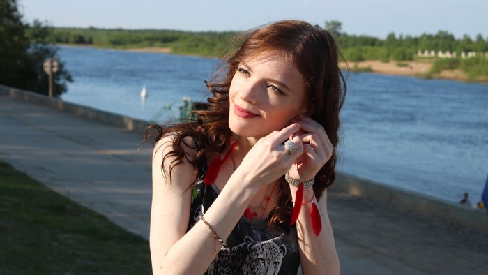Woman adjusting her earring by the river