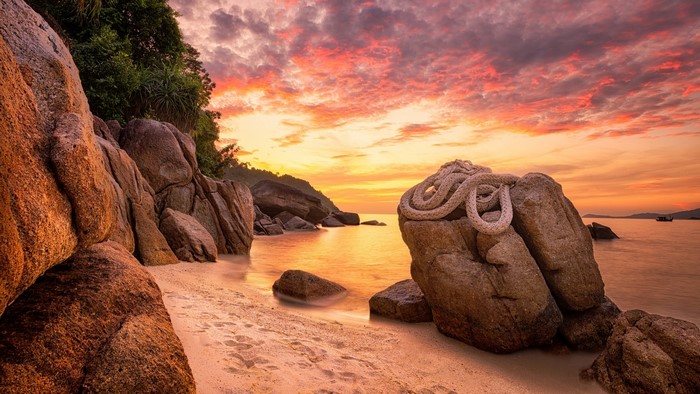 Rocky coast with rope at sunset