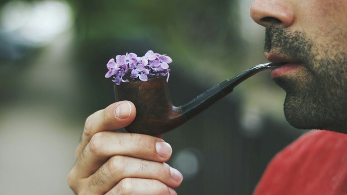 Man holding a pipe with flowers