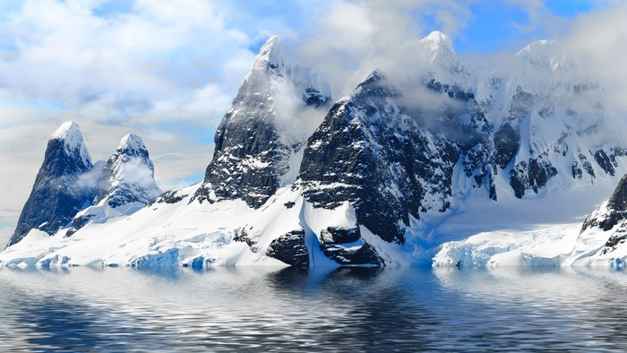 Snow-capped mountains reflected in water