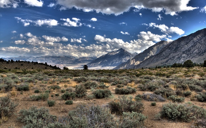 Mountain range with dry brush and clouds