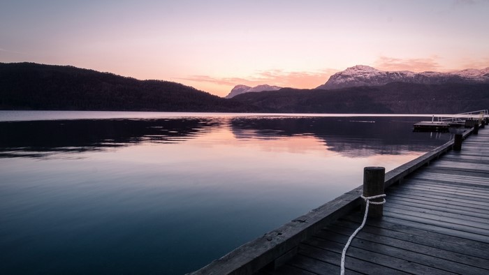 Wooden pier on a calm lake at sunset