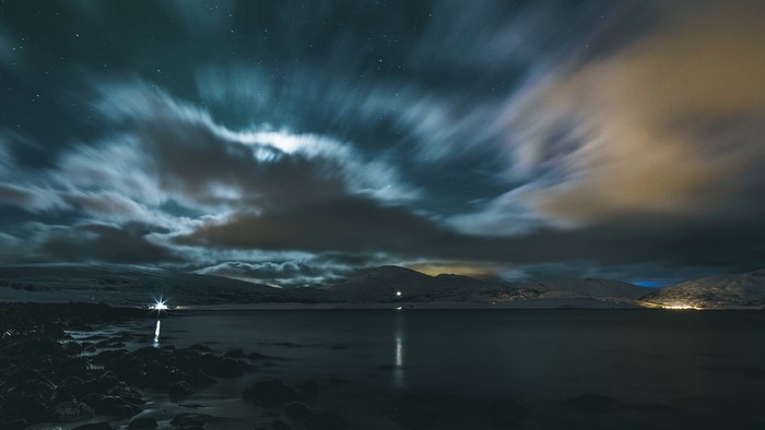 Starry sky over a lake and mountains