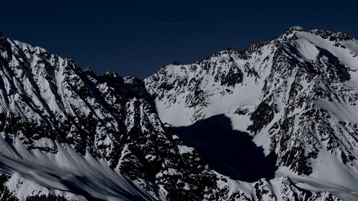 Snowy Mountain Peaks Under Dark Sky