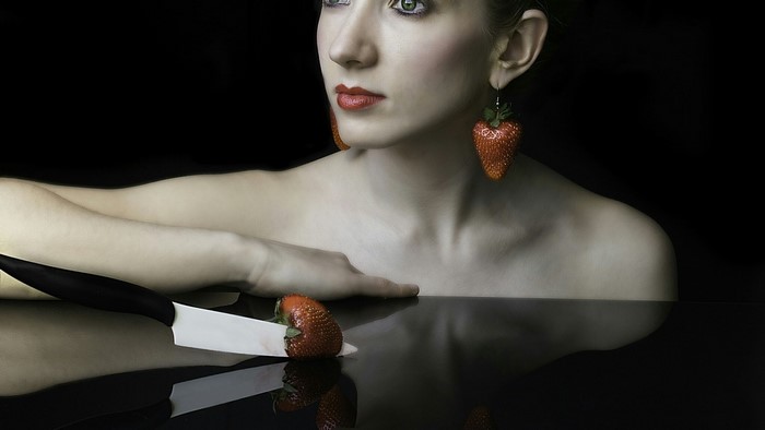 Woman with strawberry earrings and knife