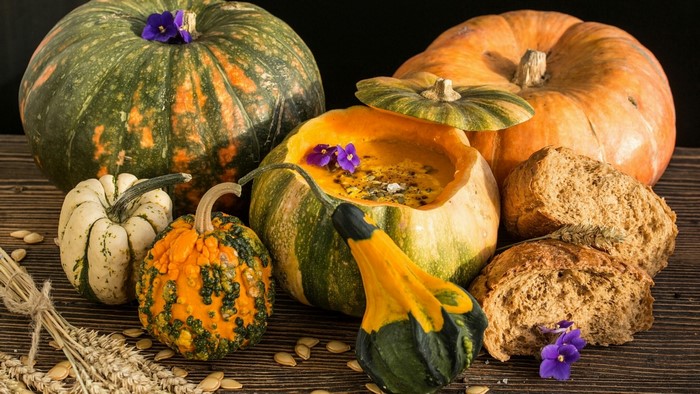 Assortment of pumpkins and bread on a wooden table