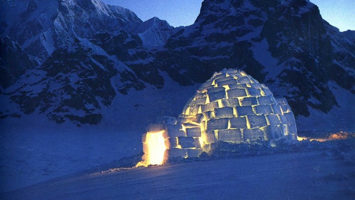 Igloo in a snowy mountain landscape at dusk