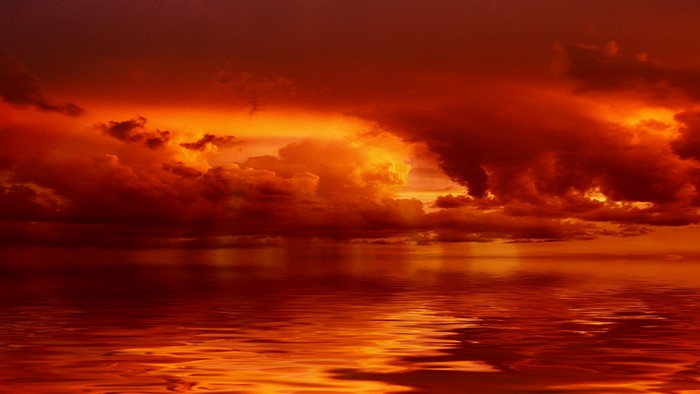 Fiery sunset over the ocean with dramatic clouds