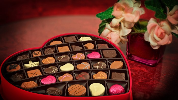 Heart-shaped box of chocolates with flowers