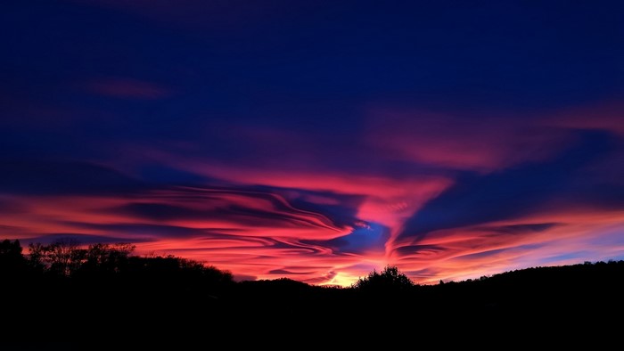 Dramatic Sunset Sky Over Silhouetted Hills
