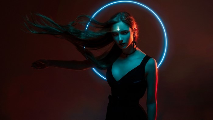 Woman with inverted cross on forehead in neon circle