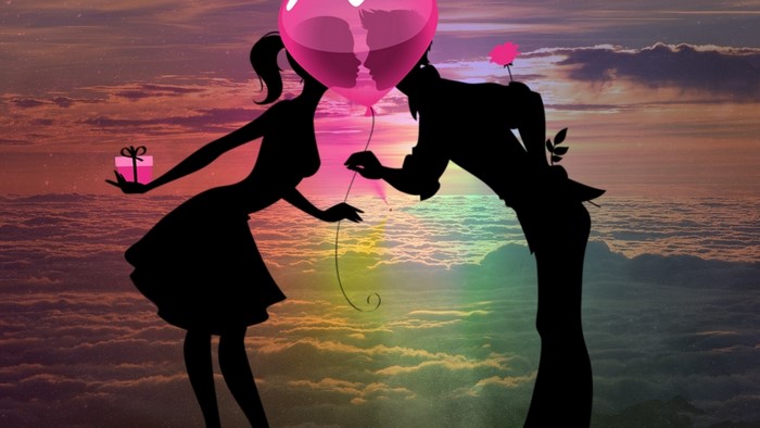 Couple silhouette with heart balloon at sunset