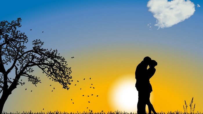 Couple kissing at sunset with heart cloud