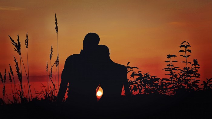 Couple silhouetted against sunset