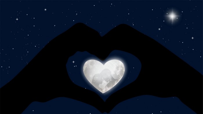 Hands forming a heart with a moon inside