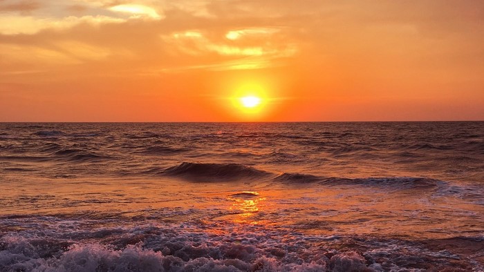 Sunset over the ocean with waves
