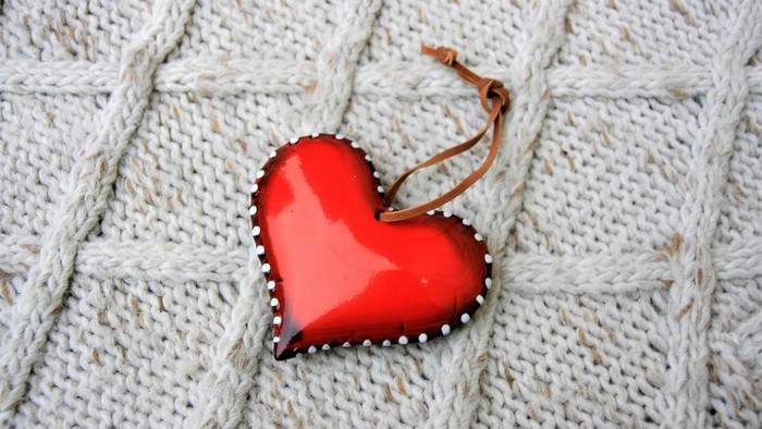 Red heart ornament on knitted background