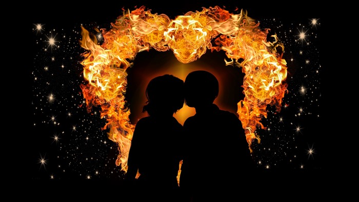 Couple silhouetted in a heart of fire