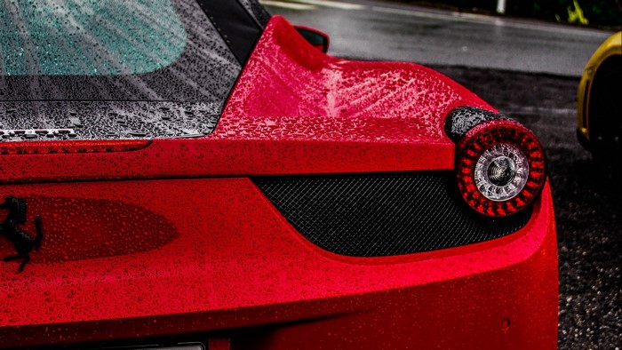 Red Ferrari sports car with water droplets