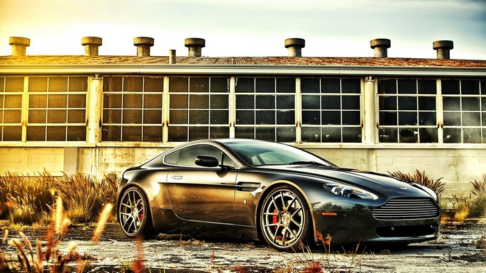 Aston Martin Vantage parked near an industrial building