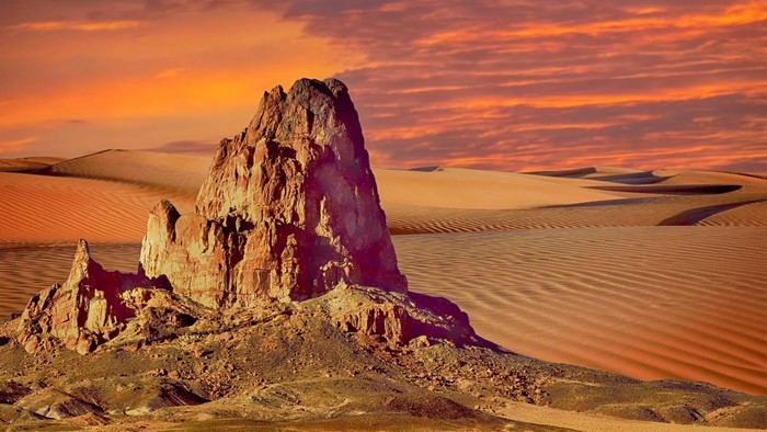 Desert landscape with rock formation at sunset
