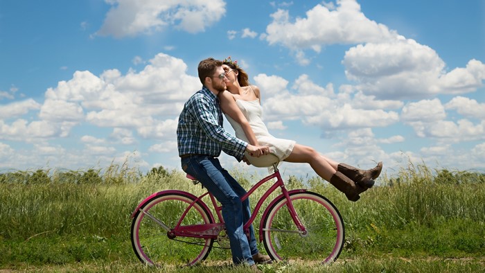 Couple on a bicycle in a field