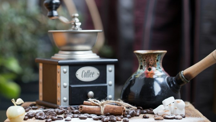 Coffee grinder, cezve, cinnamon sticks, sugar cubes, and coffee beans
