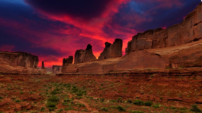 Desert landscape with red rock formations and sunset sky