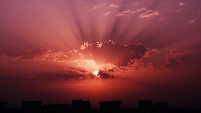 Sunset with sun rays over buildings