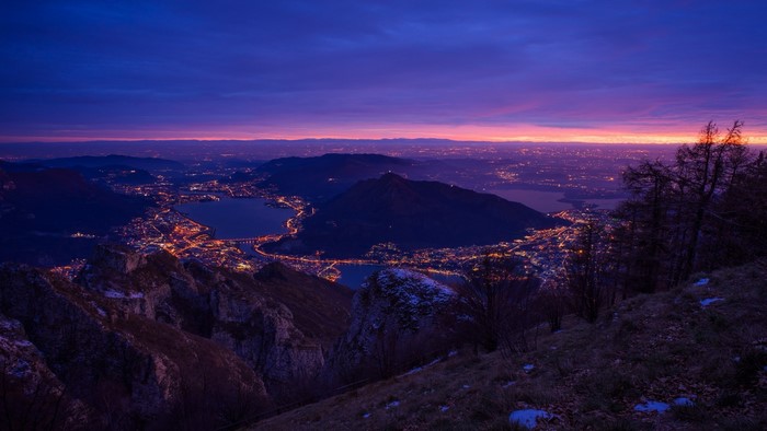 City lights on a lake at dusk from a mountain