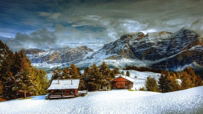 Winter mountain landscape with cabins and snow