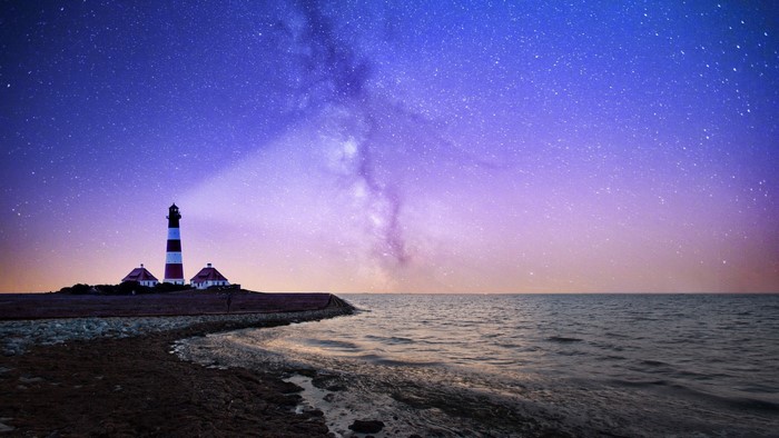 Lighthouse on the coast under the Milky Way