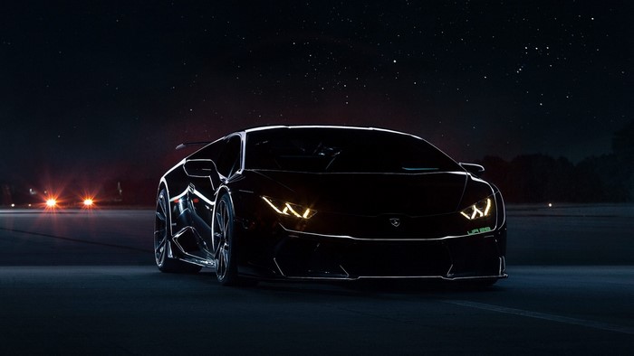 Black Lamborghini Huracan on a dark road at night