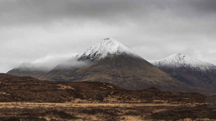 Snow-capped mountains under a cloudy sky