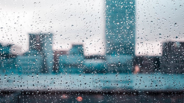 Raindrops on glass with city skyline