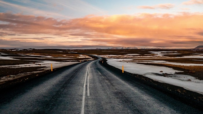 Road through a barren landscape at sunset