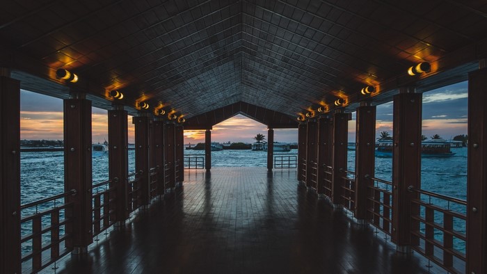 Wooden pier with boats at sunset