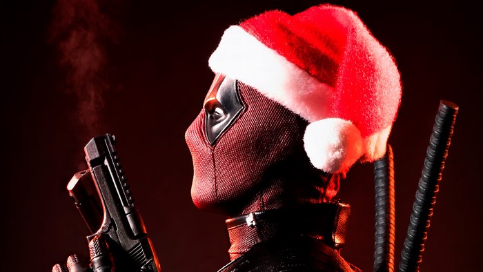 Deadpool wearing a Santa hat with a gun