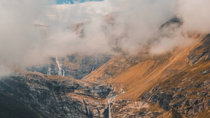 Mountain landscape with waterfalls and clouds