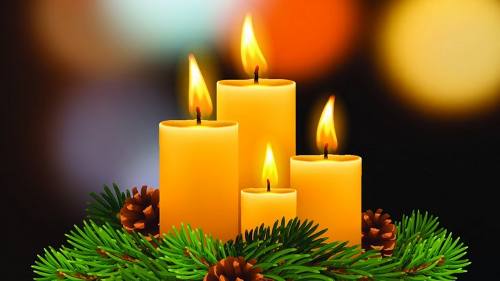 Four lit candles with pine branches and pinecones