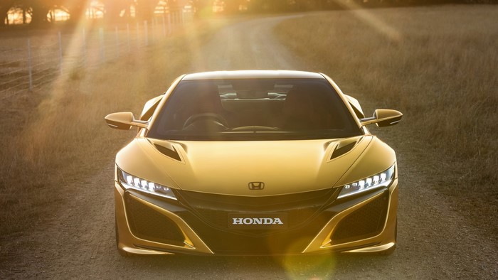 Gold Honda NSX on a dirt road at sunset