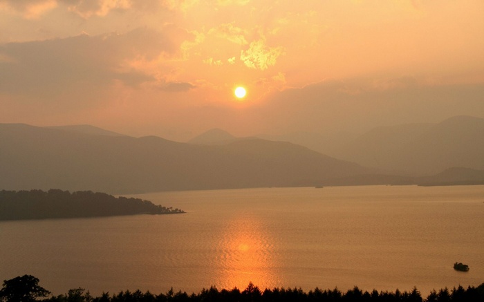 Sunset over a misty lake and mountains