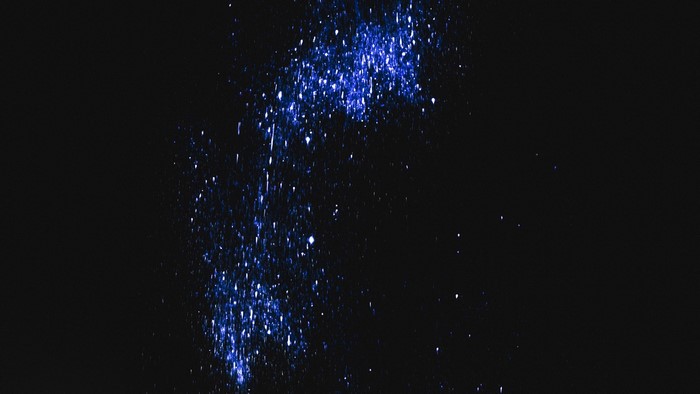 Blue glitter particles on a black background