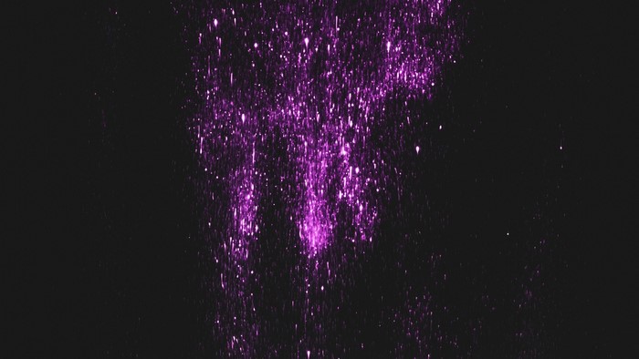 Purple glitter particles on black background