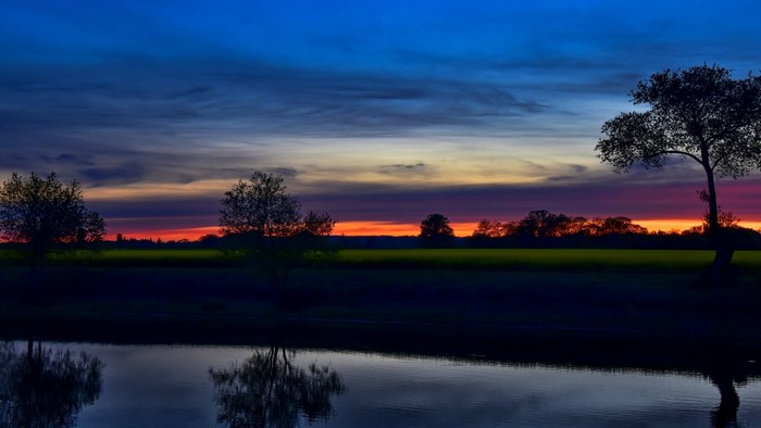 Sunset over a river with trees