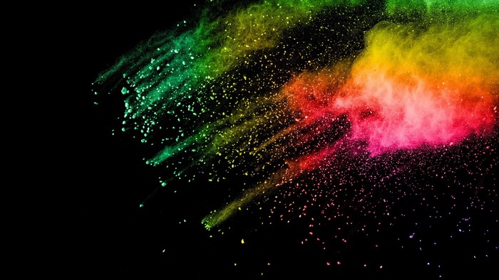 Colorful powder explosion against black background