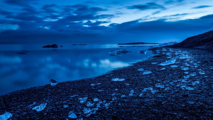 Icebergs on a dark beach by the ocean
