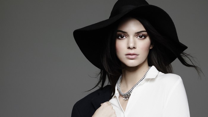 Kendall Jenner wearing a black hat and white shirt